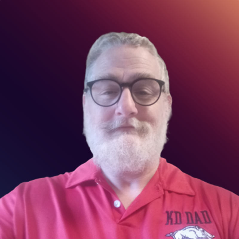 Headshot of Joe Holmin in a red shirt with a red background
